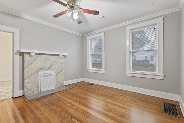 unfurnished living room featuring light wood-type flooring, ceiling fan, and crown molding