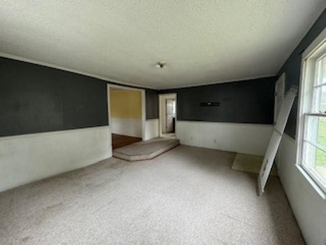 unfurnished room featuring a textured ceiling and a healthy amount of sunlight