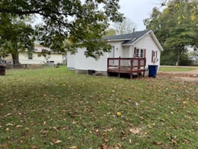 rear view of property featuring a wooden deck and a yard