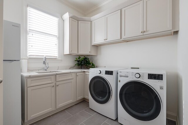 washroom featuring washer and clothes dryer, a healthy amount of sunlight, crown molding, sink, and light tile patterned flooring