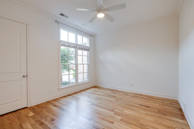 empty room featuring a healthy amount of sunlight, light hardwood / wood-style floors, and ornamental molding