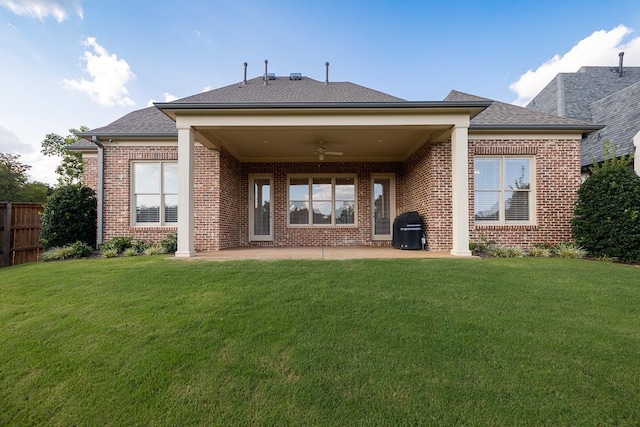 rear view of property featuring a lawn, a patio area, and ceiling fan