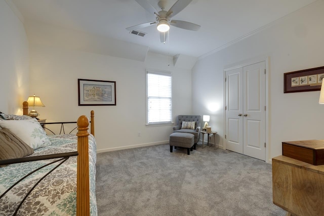 bedroom featuring ornamental molding, light colored carpet, vaulted ceiling, ceiling fan, and a closet