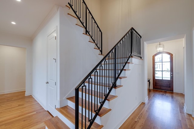 entrance foyer featuring light hardwood / wood-style floors, crown molding, and a notable chandelier