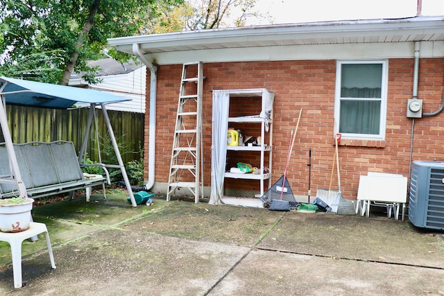 view of outdoor structure featuring fence and central air condition unit