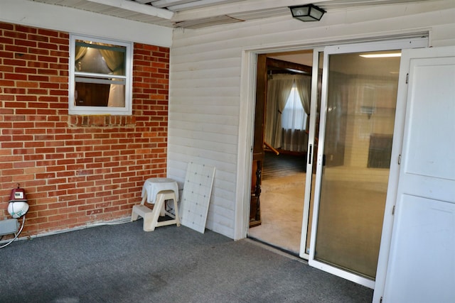 view of exterior entry featuring brick siding