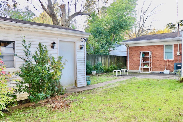 view of yard with central air condition unit, fence, and an outdoor structure