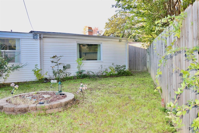 view of property exterior featuring a chimney, a fenced backyard, and a lawn