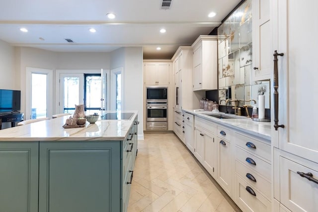 kitchen featuring white cabinets, sink, a kitchen island, and black electric cooktop