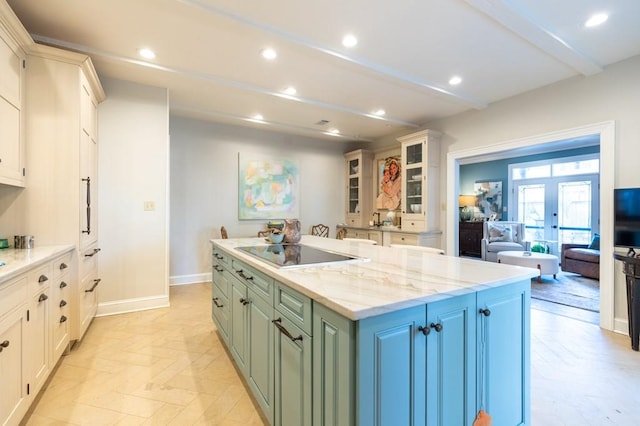 kitchen featuring black electric cooktop, light stone countertops, green cabinetry, a center island, and french doors