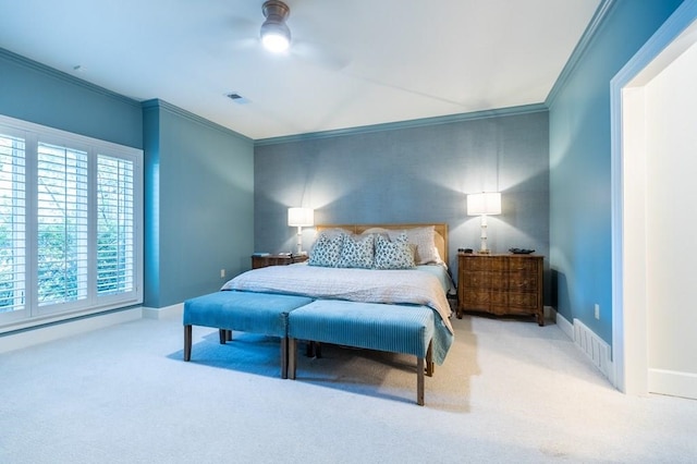 carpeted bedroom with ceiling fan and ornamental molding