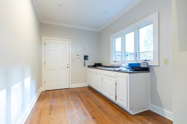 kitchen featuring white cabinetry, light hardwood / wood-style flooring, and ornamental molding