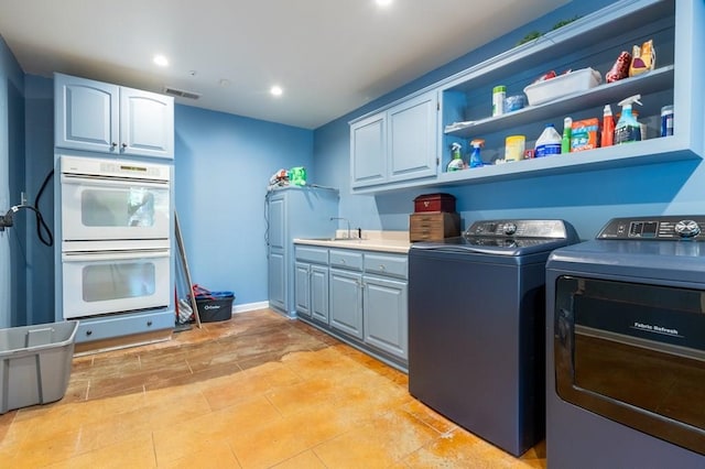 clothes washing area featuring washing machine and dryer and sink