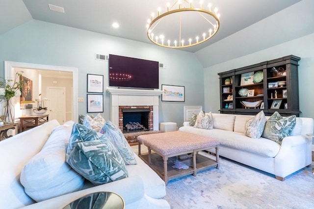 living room with a brick fireplace, a chandelier, and lofted ceiling