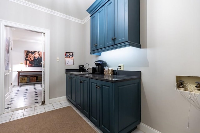 bar featuring blue cabinetry, ornamental molding, sink, and light tile patterned floors