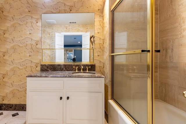 bathroom featuring vanity and bath / shower combo with glass door