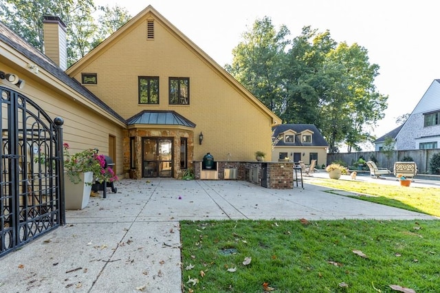 back of property with a lawn and a patio