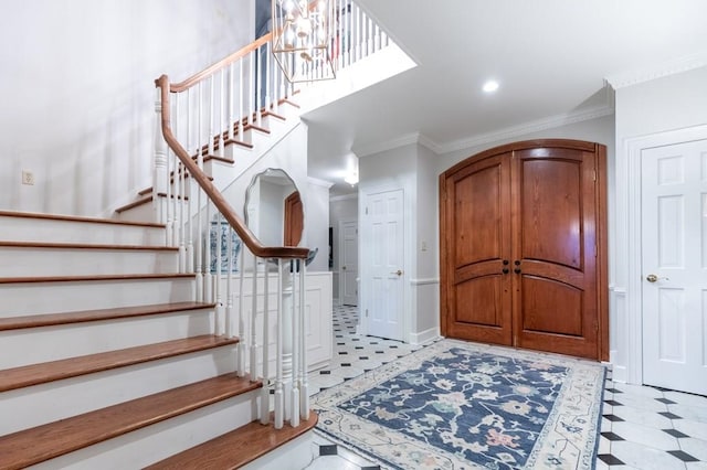 entryway featuring a chandelier and crown molding