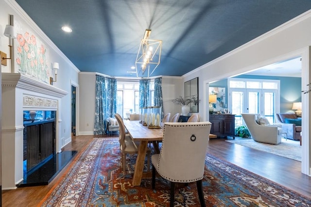 dining room featuring ornamental molding, a wealth of natural light, dark wood-type flooring, and a notable chandelier