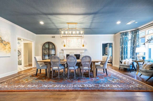 dining room with dark hardwood / wood-style floors, an inviting chandelier, and ornamental molding