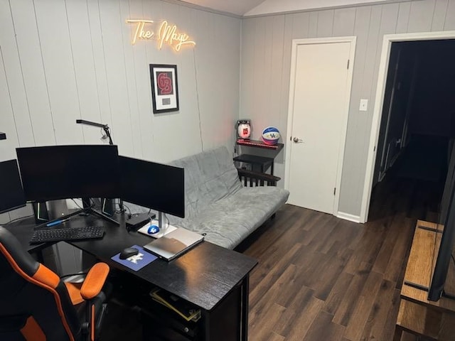 home office with dark hardwood / wood-style floors and wooden walls