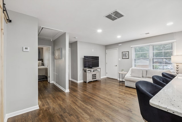 living room featuring dark hardwood / wood-style flooring and a barn door