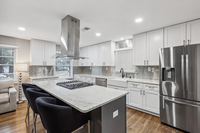 kitchen featuring white cabinets, island range hood, a kitchen island, appliances with stainless steel finishes, and dark hardwood / wood-style floors