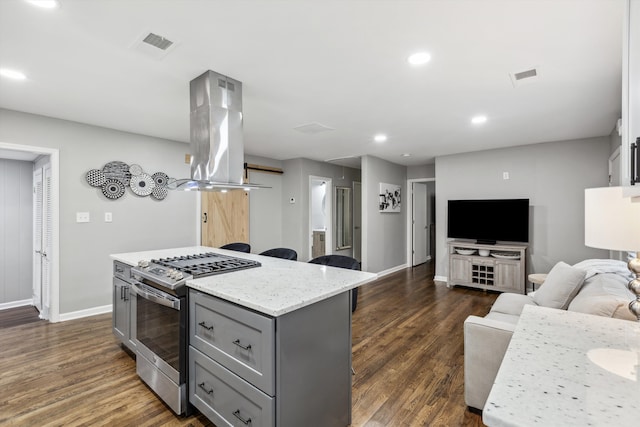 kitchen featuring gray cabinetry, a center island, stainless steel range with gas cooktop, dark hardwood / wood-style floors, and island exhaust hood