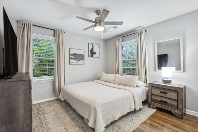 bedroom featuring multiple windows, ceiling fan, and hardwood / wood-style flooring