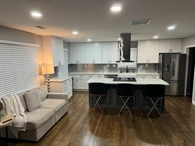 kitchen featuring a kitchen bar, white cabinets, extractor fan, dark hardwood / wood-style flooring, and stainless steel fridge with ice dispenser