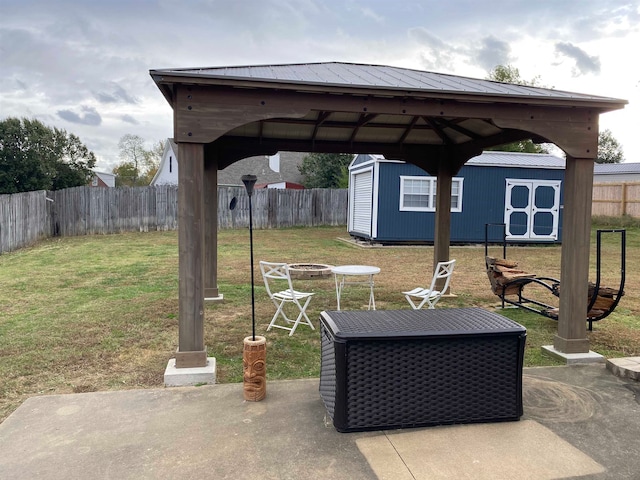 view of patio featuring an outbuilding, a fenced backyard, a gazebo, and a storage unit