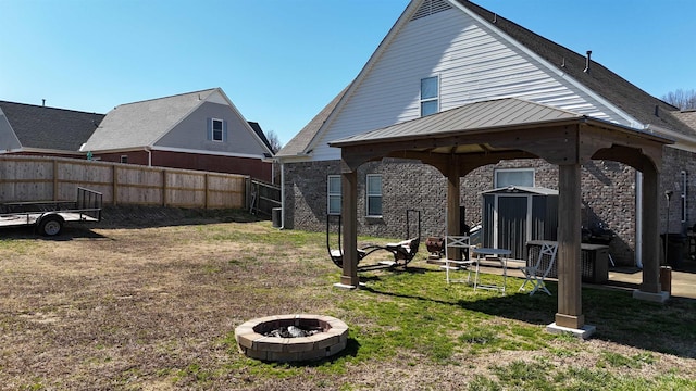 view of yard with an outdoor fire pit, fence, cooling unit, and a gazebo