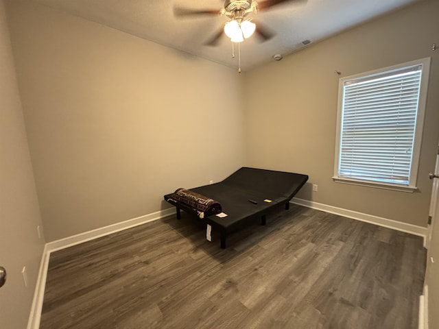 unfurnished bedroom with dark wood-style floors, baseboards, and a ceiling fan