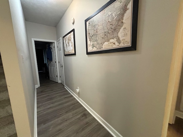 hall featuring dark wood-style floors and baseboards