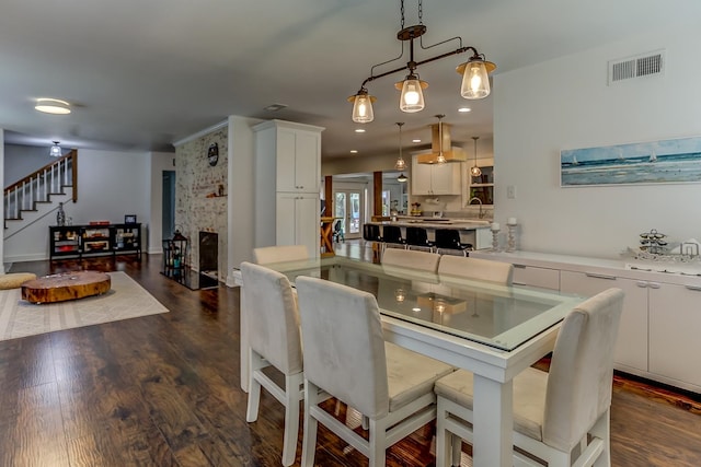 dining area featuring dark wood-type flooring and a fireplace