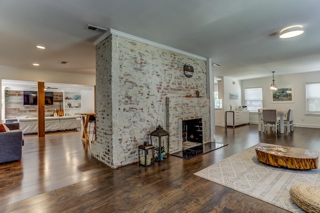 living room featuring dark hardwood / wood-style flooring and a large fireplace