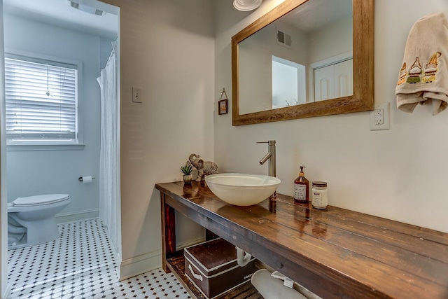 bathroom featuring tile patterned flooring, sink, and toilet