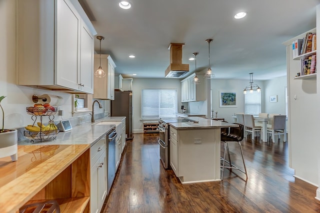 kitchen with dark wood-type flooring, a center island, hanging light fixtures, light stone countertops, and white cabinetry