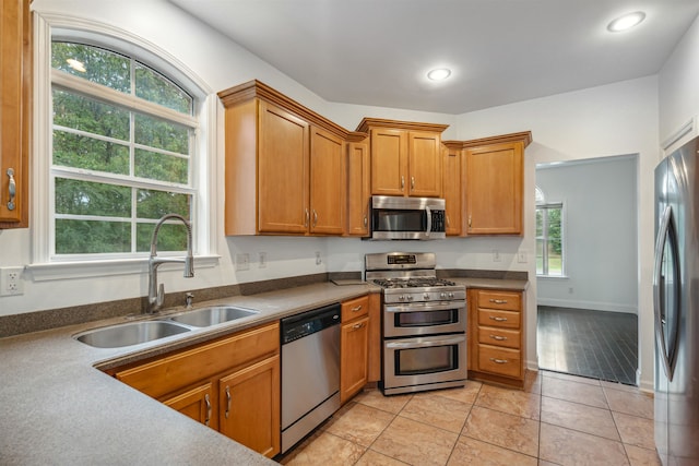 kitchen with light tile patterned floors, a wealth of natural light, sink, and appliances with stainless steel finishes