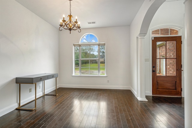 entryway featuring an inviting chandelier, dark hardwood / wood-style flooring, and decorative columns