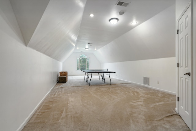 interior space featuring lofted ceiling and light carpet