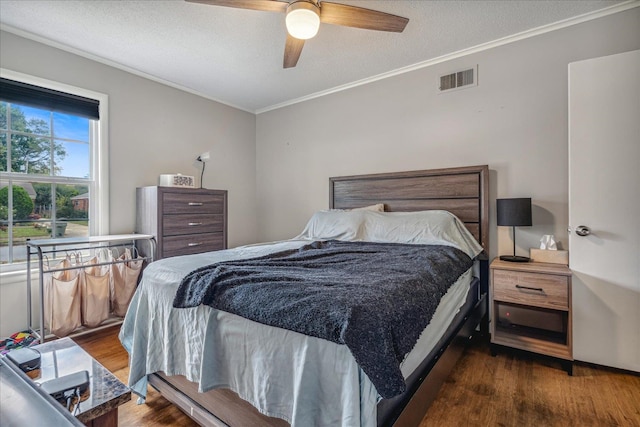 bedroom with dark hardwood / wood-style flooring, ornamental molding, a textured ceiling, and ceiling fan