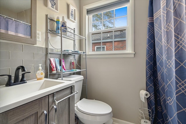 bathroom with toilet, backsplash, and vanity