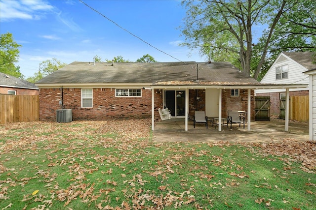 rear view of property with a patio, cooling unit, and a yard