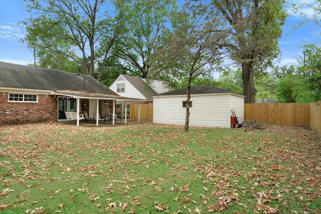 rear view of property with a yard, a storage shed, and a patio area