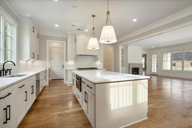 kitchen with white cabinets, a healthy amount of sunlight, sink, and a kitchen island