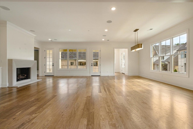 unfurnished living room with light hardwood / wood-style flooring and crown molding