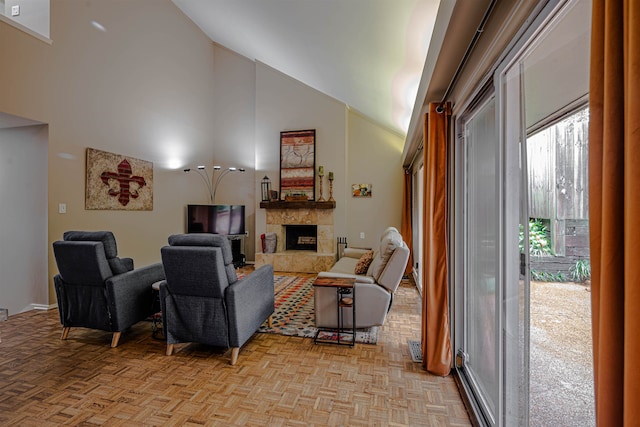 living room with a stone fireplace, light parquet flooring, and high vaulted ceiling