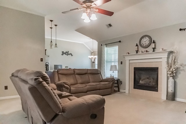 carpeted living room with ornamental molding, a fireplace, ceiling fan with notable chandelier, and lofted ceiling