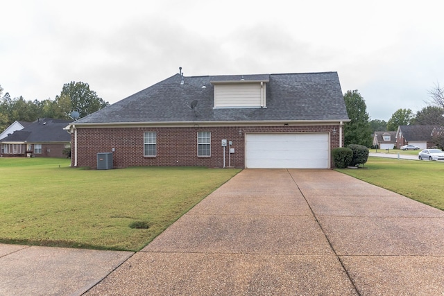 exterior space with central air condition unit, a garage, and a yard